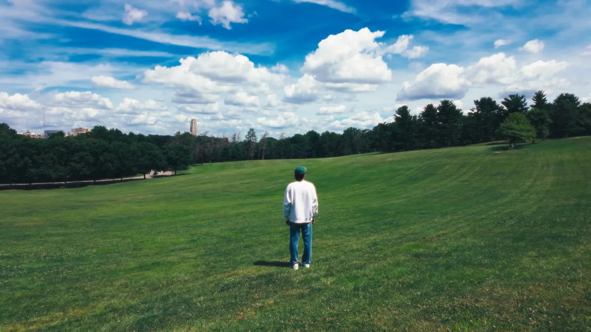 A cinematic frame of Ben beneath a wide summer sky
