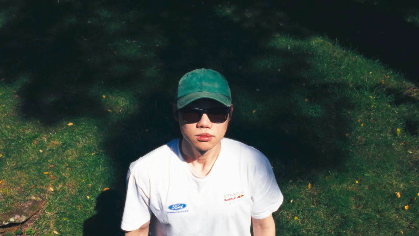 Ben Kim outdoors in a green cap and sunglasses