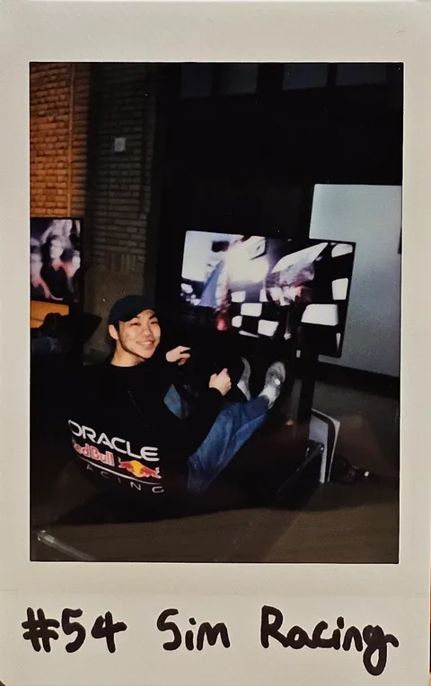 Ben at a sim racing setup, photographed on instant film